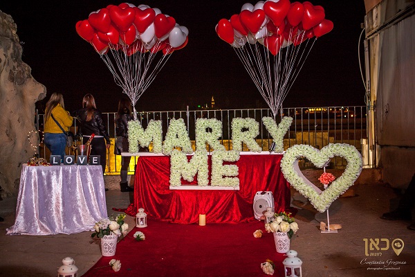 הצעת נישואין בכותל עם שלט פרחים